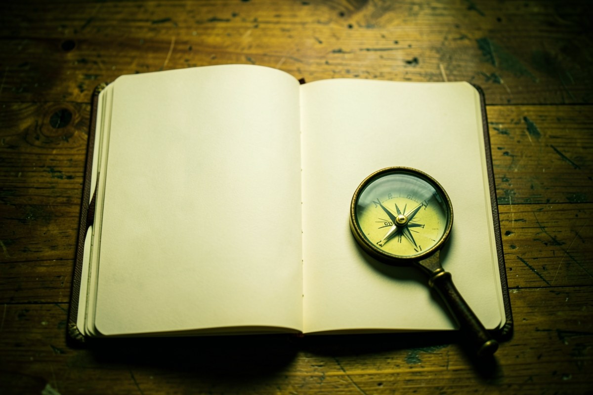 A neatly arranged desk with a notebook, a compass, and a magnifying glass, representing the site's editorial research and transparent approach.