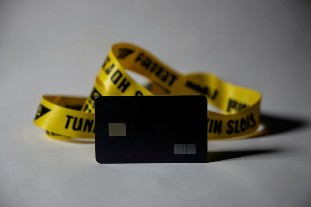 A caution tape reading 'void' with a single credit card, symbolizing limits and legal disclaimers.